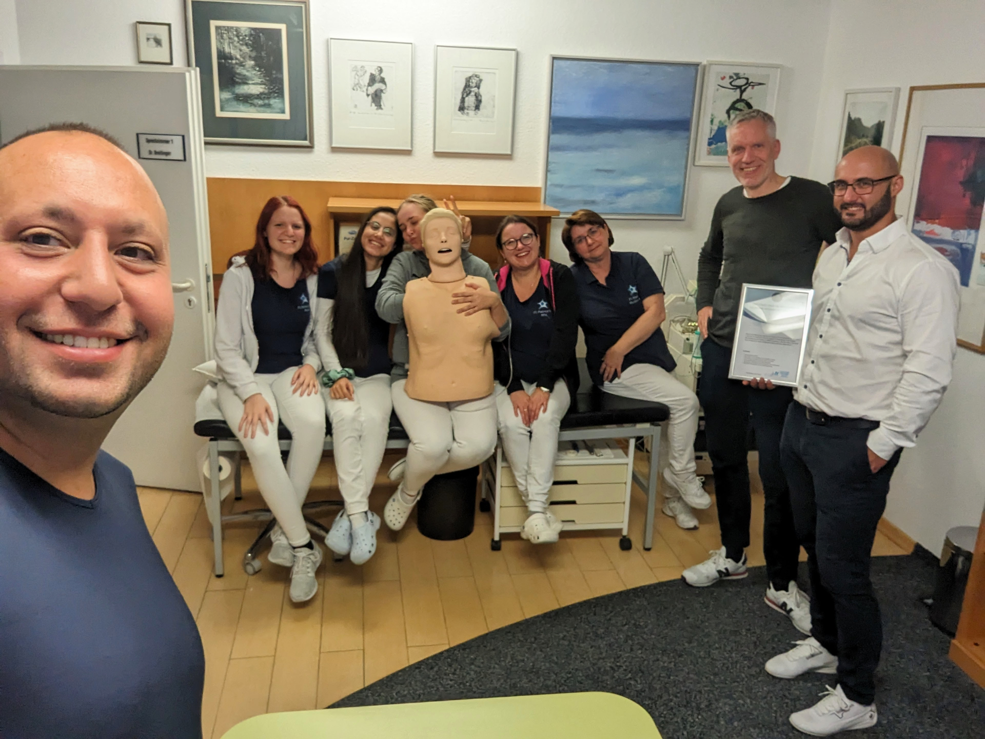Praxisteam mit Zertifikat und Reanimationsphantom nach dem Notfalltraining