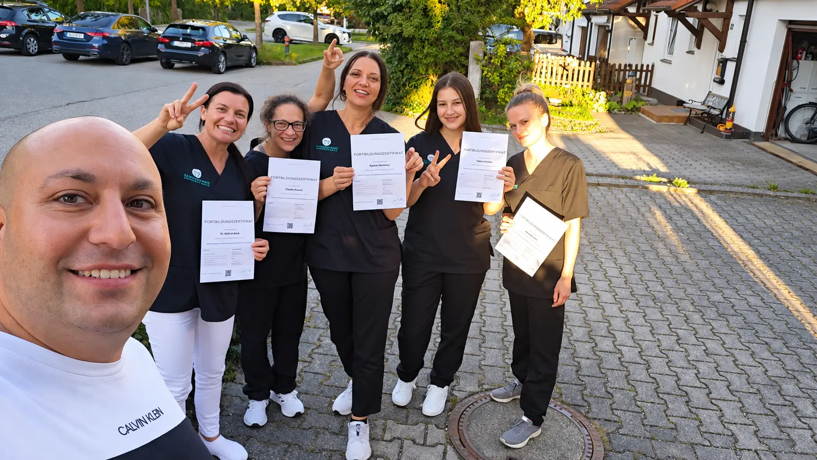 Zahnarztpraxis-Team zeigt seine Fortbildungszertifikate nach dem Training