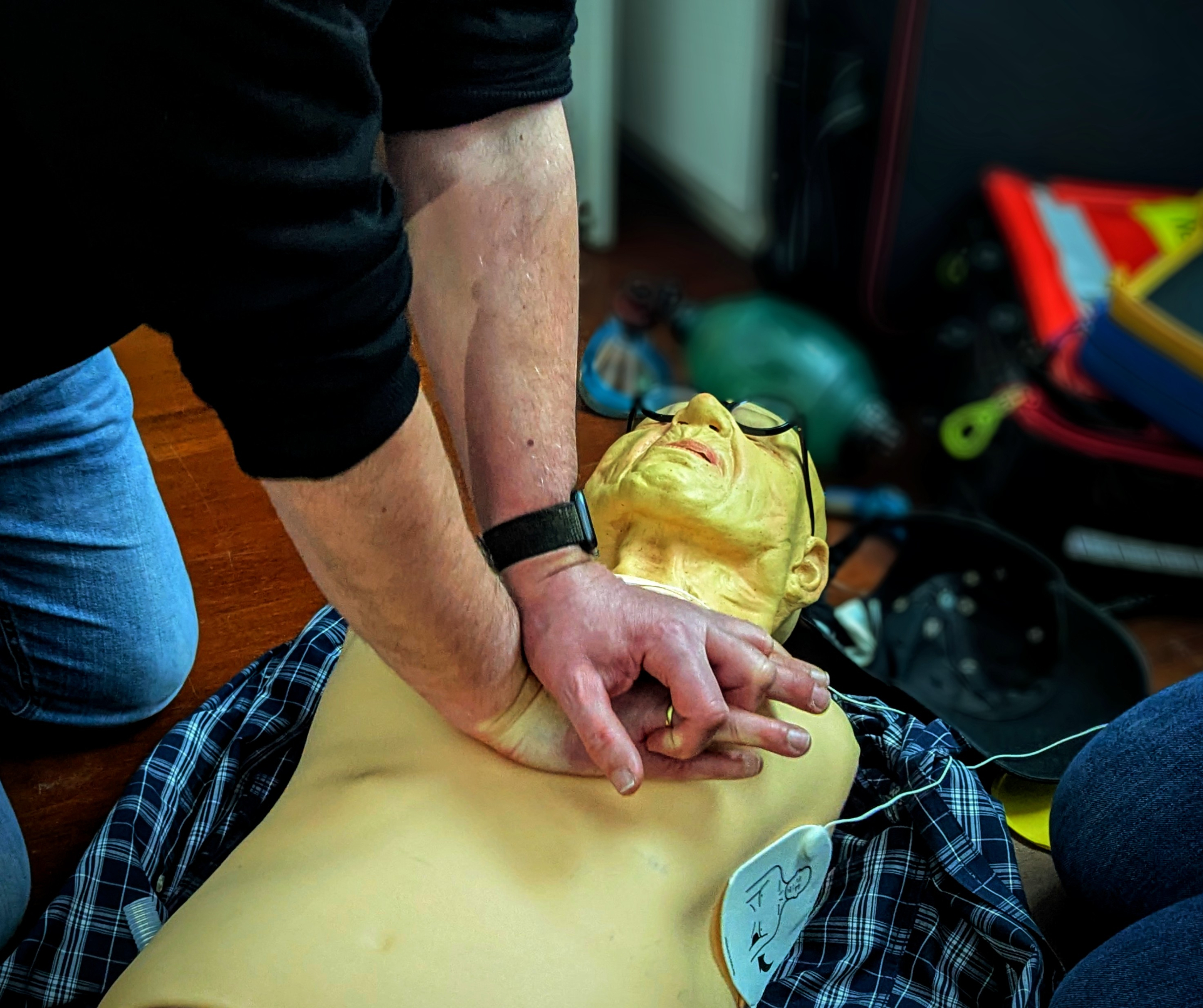 Herzdruckmassage am Phantom mit angelegtem AED – Detailaufnahme