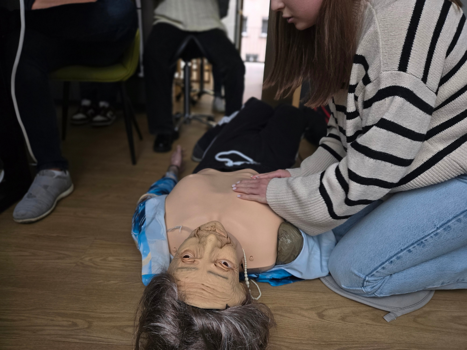 Herzdruckmassage am Senioren-Phantom mit korrekter Handposition im Praxisraum