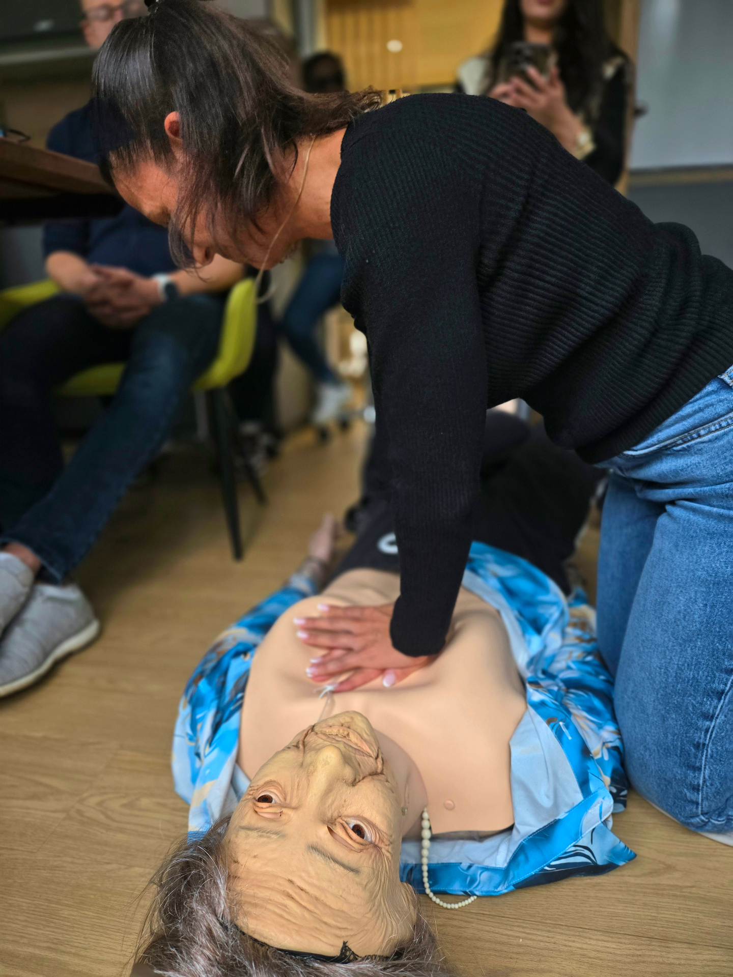 Herzdruckmassage am Senioren-Reanimationsphantom – Konzentration der Helferin