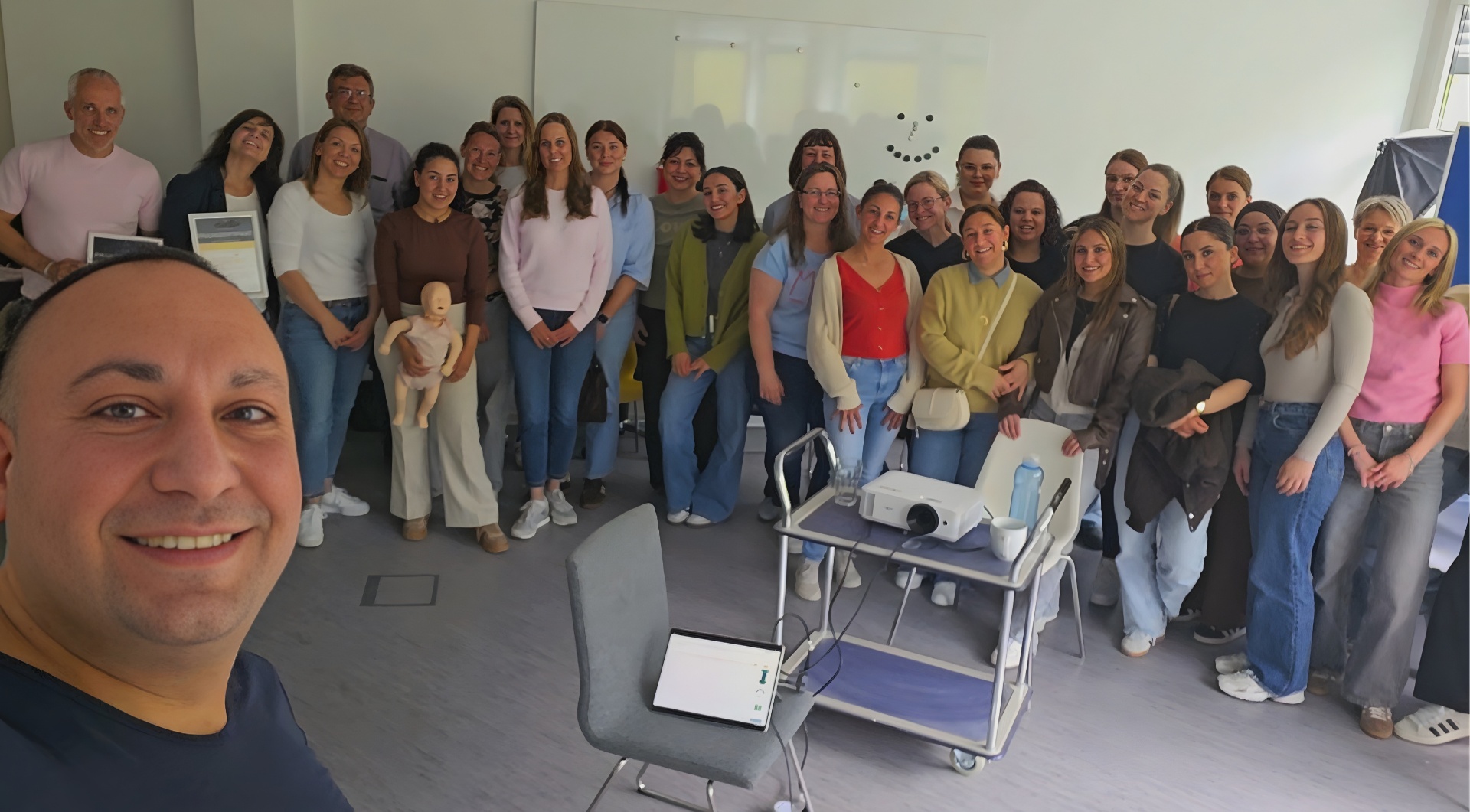 Großes Zahnarzt-Praxisteam nach Notfalltraining mit Baby-Reanimationsphantom
